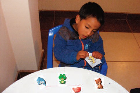 Niño utilizando el metodo tradicional de ensenanza con fichas impresas.