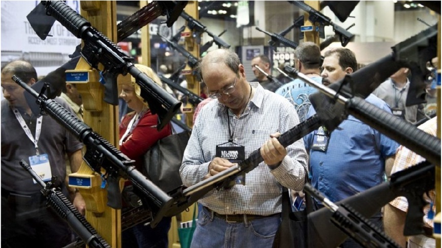 Un hombre examina un arma en la reunión de la Asociación Nacional del Rifle en Indianápolis, en 2014.