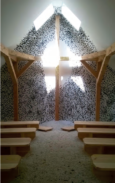 Al interior de la capilla de Terunobu Fujimori, la cruz de madera es un elemento estructural que aparece del encuentro de la viga con una columna de pequeñas hojas de oro y tres clavos. La blanca pared posterior está salpicada de trozos de carbón que crean un espacio luminoso