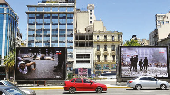 En esta fotografía puede reconocerse el tamaño que tuvieron las estructuras y las imágenes emplazadas en las avenidas. A diferencia de las imágenes emplazadas en el sitio mismo de la toma fotográfica original, éstas tienen un borde negro para separarlas del fondo.