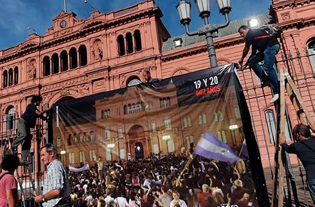 Fotografía del colgado de las imágenes en el mismo sitio de la toma original frente a la Casa Rosada