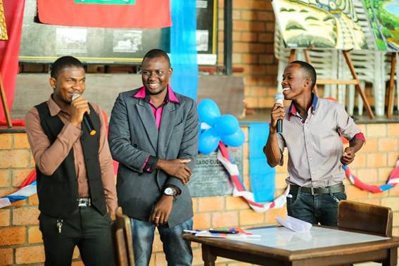 Foto 1: Os imigrantes haitianos,
Valner, Rosemond e Phillipe, comunicando sobre os precedentes históricos da
Bandeira Haitiana para os participantes da oficina temática “Marchando Unidos:
Pró-Haiti”. No plano de fundo, obras de um artista plástico haitiano.