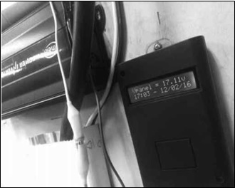 Detalle del prototipo de monitoreo (der.) instalado junto a la acometida del panel solar. (Se puede notar el detalle de la pantalla LCD reportando voltaje)