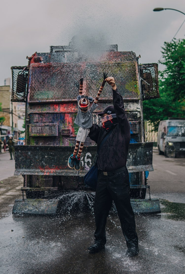 Manifestante con su muñeco en frente al carro policial, Valparaíso.